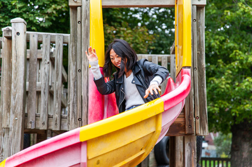 Jiali sliding down a kiddie slide.