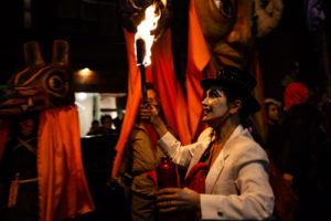 Winter Solstice Parade in Kensington market. A woman holding a lit torch.